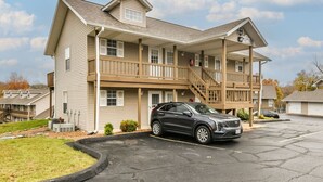 A two-story building with a covered front porch and a staircase leading to the upper level.