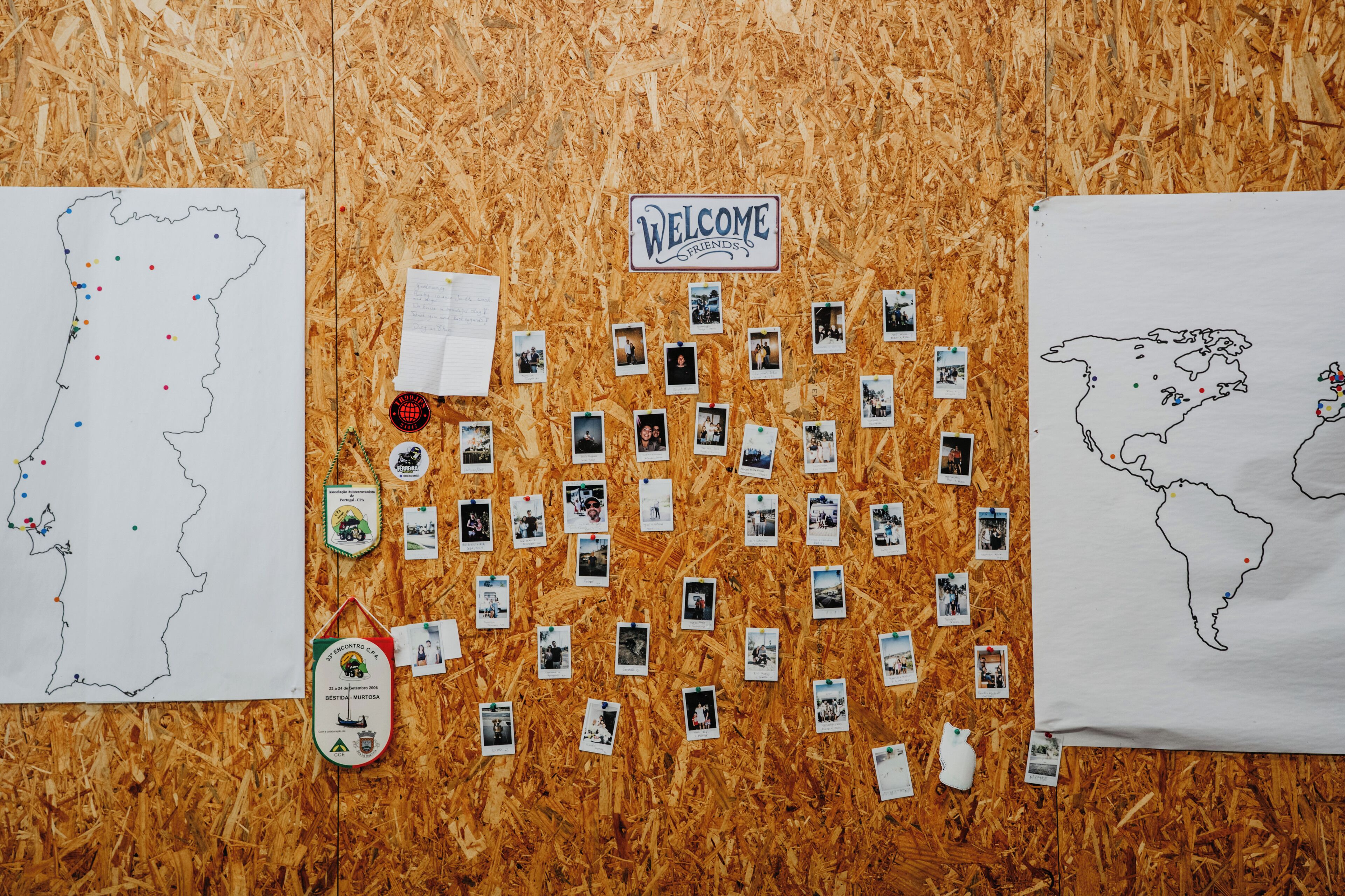A bulletin board with a map, photos, and a welcome sign.