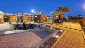 A beachfront property with wooden cabins, outdoor seating, and a wooden deck. - Beachside Container Tiny Home Saltwater Oasis (Fort Walton Beach)