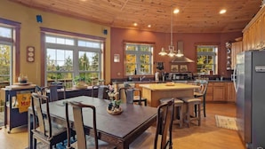 Una cocina amplia con armarios de madera, una isla grande y una zona de comedor con mesa y sillas.