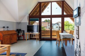 A modern interior with a TV, dining table, and chairs.