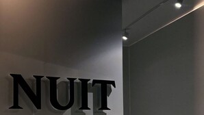 Un interior minimalista con un cartel grande y llamativo que dice 'NUIT'.