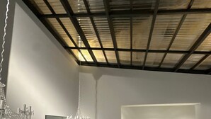 Un interior moderno con comedor que incluye una mesa redonda, sillas, una lámpara de araña y un espejo grande.