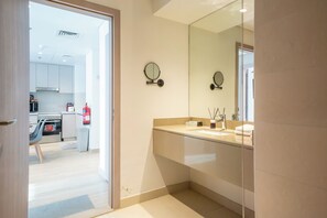 Et moderne badeværelse med et stort spejl, en vask og et toilet.