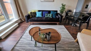 Un salon comprenant un canapé, une table basse et un coin repas avec des chaises.