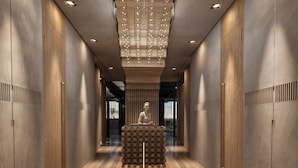 A modern interior with a central reception desk, wooden panel walls, and a geometric light fixture. - Nearchou Boutique Hotel (Chania)