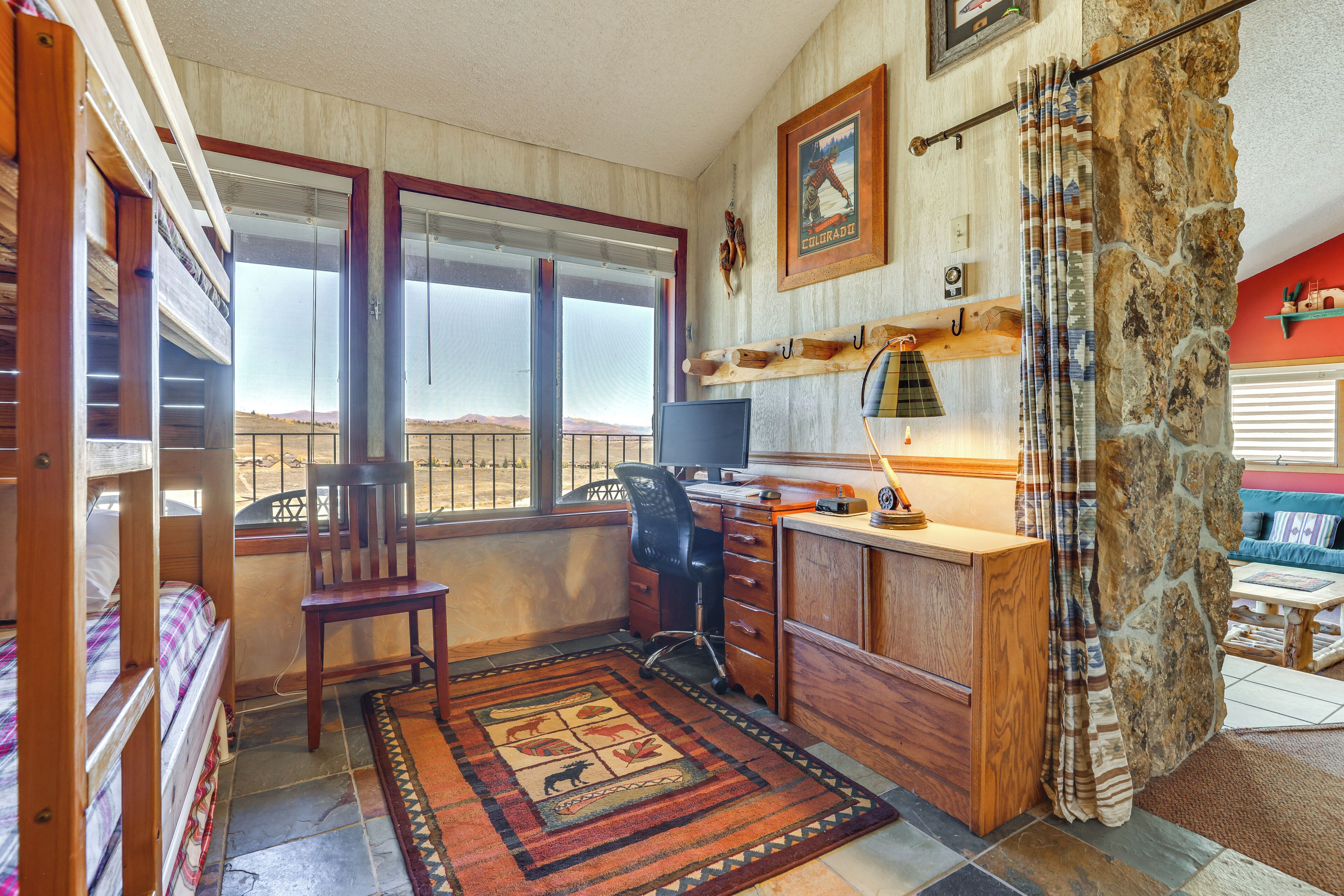 A compact living space with a desk, chair, and bunk beds.