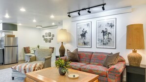 Una sala moderna con un sofá, una mesa de centro y un comedor al fondo.