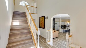 A staircase with wooden steps and white balusters leading to an upper floor. - Game Room & Deck: Modern Frazier Park Home! (Pine Mountain Club)
