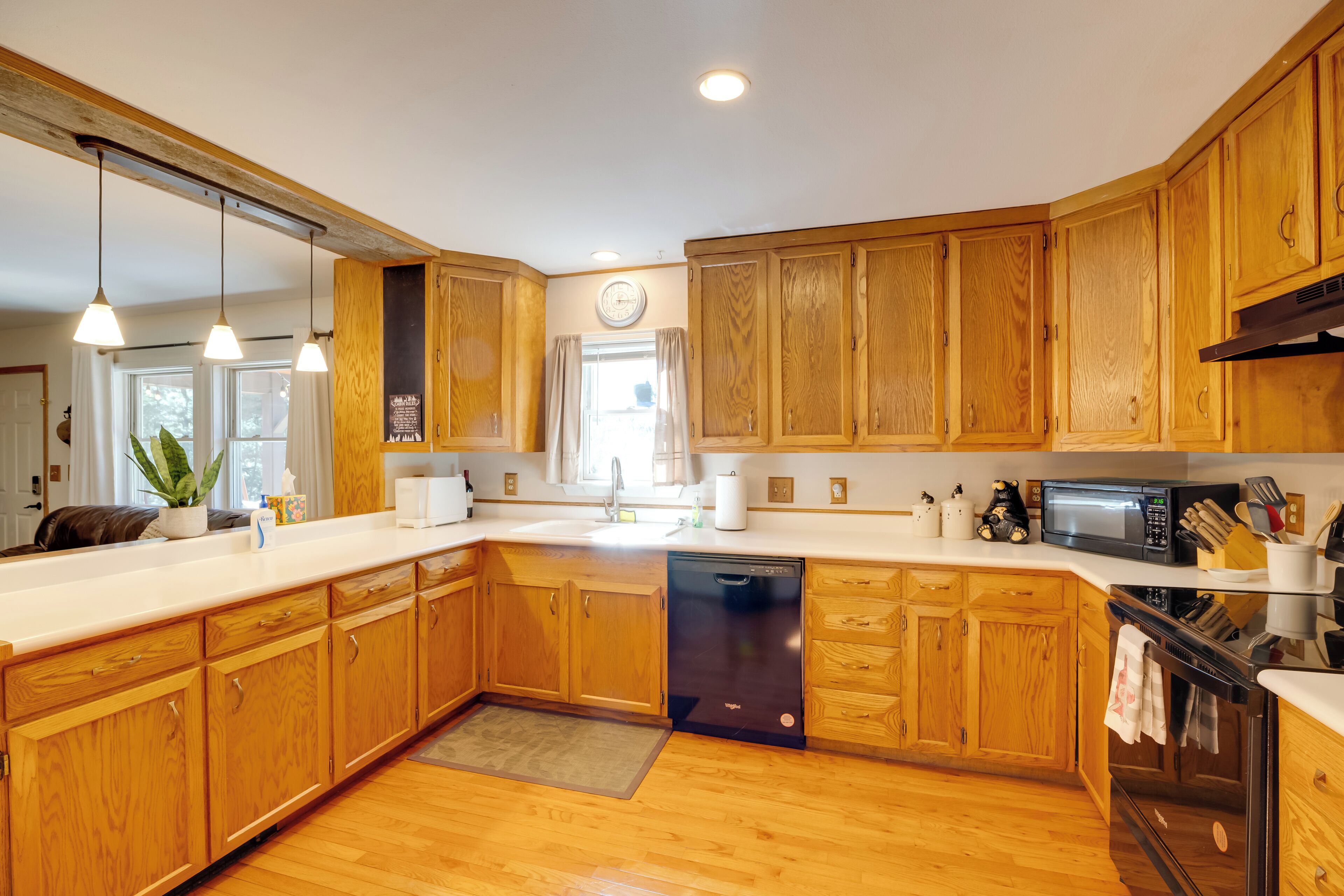 A kitchen with wooden cabinets, a dishwasher, a microwave, and a stove.
