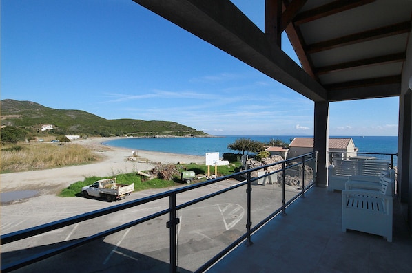 A balcony with a view of a beach and ocean.