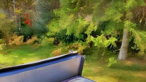 A hot tub with a wooden deck and a grassy yard in the background. - Spa & Private Beach | Chalet Natura Versailles (Saint-Côme)