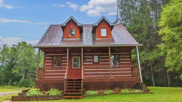 A wooden cabin with a front porch, two windows, and a small porch area. - Spa & Private Beach | Chalet Natura Versailles (Saint-Côme)