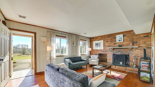 A living room with a fireplace, a sofa, a coffee table, and a TV. - Quiet Catskill Getaway w/ Fire Pit - Near Hiking! (Catskill)
