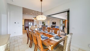 A spacious dining area with a large wooden table set for six, surrounded by wooden chairs. - 'paradise Palms' Cape Coral Home w/ Dock! (Cape Coral)
