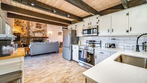 A modern kitchen with white cabinets, stainless steel appliances, and a wooden ceiling. - Walk to Liberty Mountain: Lake-view Ski Retreat! (Fairfield)
