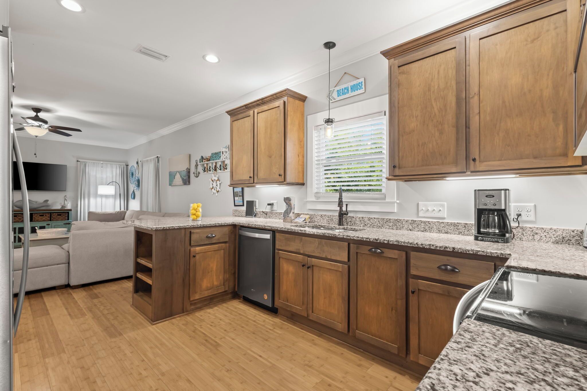 A modern kitchen with wooden cabinets, granite countertops, and a dishwasher.