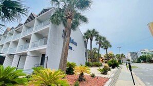A hotel with a white facade, multiple balconies, and palm trees in the foreground. - SJ9 Bright studio walk to the beach (Myrtle Beach)