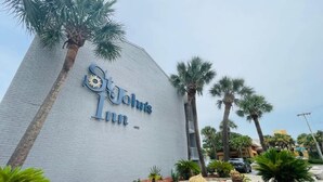 A building with a sign reading "John's Inn" and palm trees around it. - SJ9 Bright studio walk to the beach (Myrtle Beach)