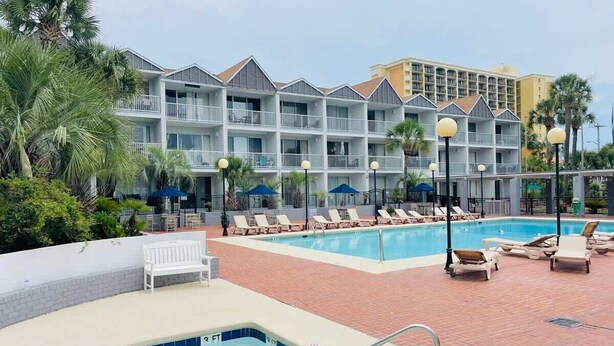 A hotel with a pool area, including a hot tub and lounge chairs. - SJ9 Bright studio walk to the beach (Myrtle Beach)