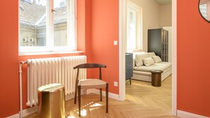 A room with a radiator, a chair, a wooden floor, and a bed with pillows. - Palais Palffy Hotel Suite in Central Vienna (Vienna)