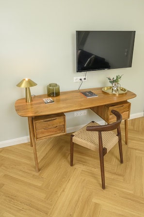 Work in comfort with a desk, chair, and flat-screen TV.