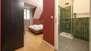 Un dormitorio con cama, ventana y pared roja.
