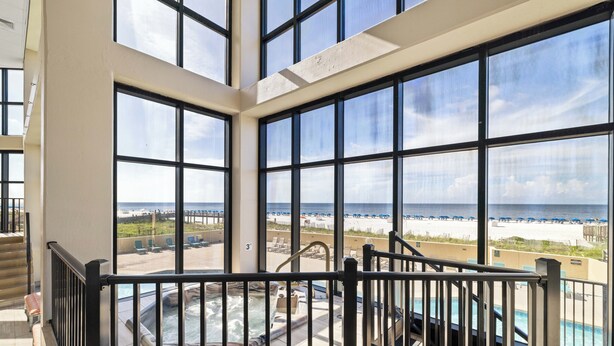 A balcony with a hot tub and a view of the beach.