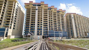 A high-rise residential building with multiple balconies and a central courtyard.