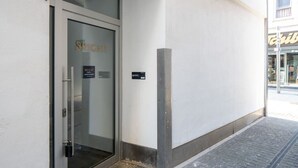 Een glazen deur met de tekst 'BRIGHT' erop, een metalen leuning en een klein bord aan de muur.