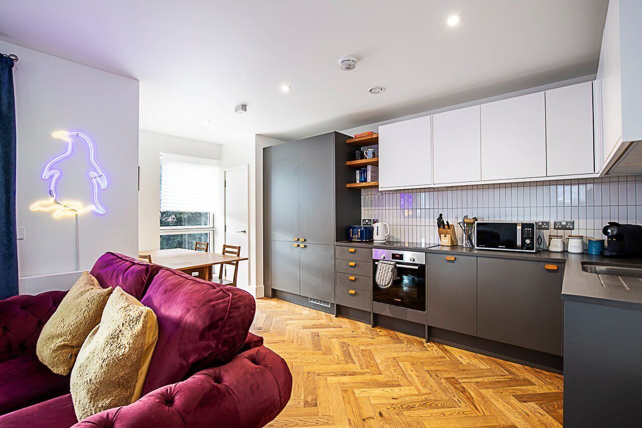 A modern kitchen with grey cabinets, a microwave, and a coffee maker.