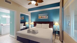 Habitación de hotel con una cama grande, dos mesitas de noche con lámparas, un cabecero y un cuadro en la pared.