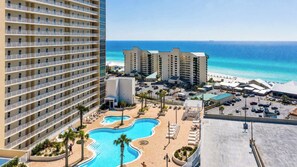 A hotel with a pool, beach, and ocean view.