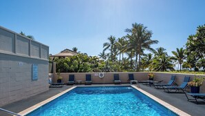 A swimming pool with lounge chairs and palm trees in the background. - Koa Lagoon #105 Ground Floor Ocean View, 1BD/1BA, Sleeps 4 (Kihei)