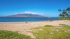 A beach with clear blue water, a sandy shore, and a mountain in the distance. - Koa Lagoon #105 Ground Floor Ocean View, 1BD/1BA, Sleeps 4 (Kihei)