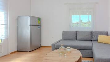 Comfort-Apartment, eingeschränkter Meerblick | Wohnbereich | 100-cm-Flachbildfernseher mit Satellitenempfang