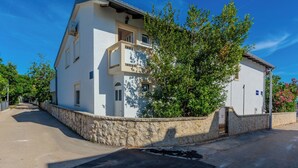 A two-story building with a stone wall and a balcony. - Apartment Jozanovic (Vir)