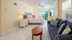 A hotel room with a bed, a sofa, a table, a ceiling fan, and a view of the outdoors. - Sundance: Ocean View, Dock, Pool, Elevator, Beach, Kayaks, Ice Machine (Marathon)