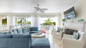 A spacious living room with a large sofa, a coffee table, and a fireplace. - Sundance: Ocean View, Dock, Pool, Elevator, Beach, Kayaks, Ice Machine (Marathon)