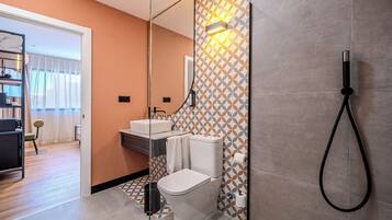 Un baño moderno con inodoro, lavamanos y ducha.