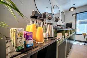 Angolo bar con bevande, una macchina per caffè e vista sulla città.
