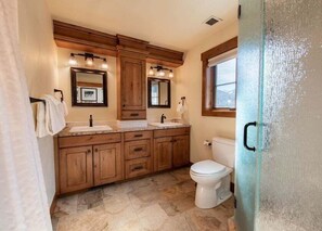 Ein Badezimmer mit Holzausstattung, einer weißen Toilette und einem Fenster.