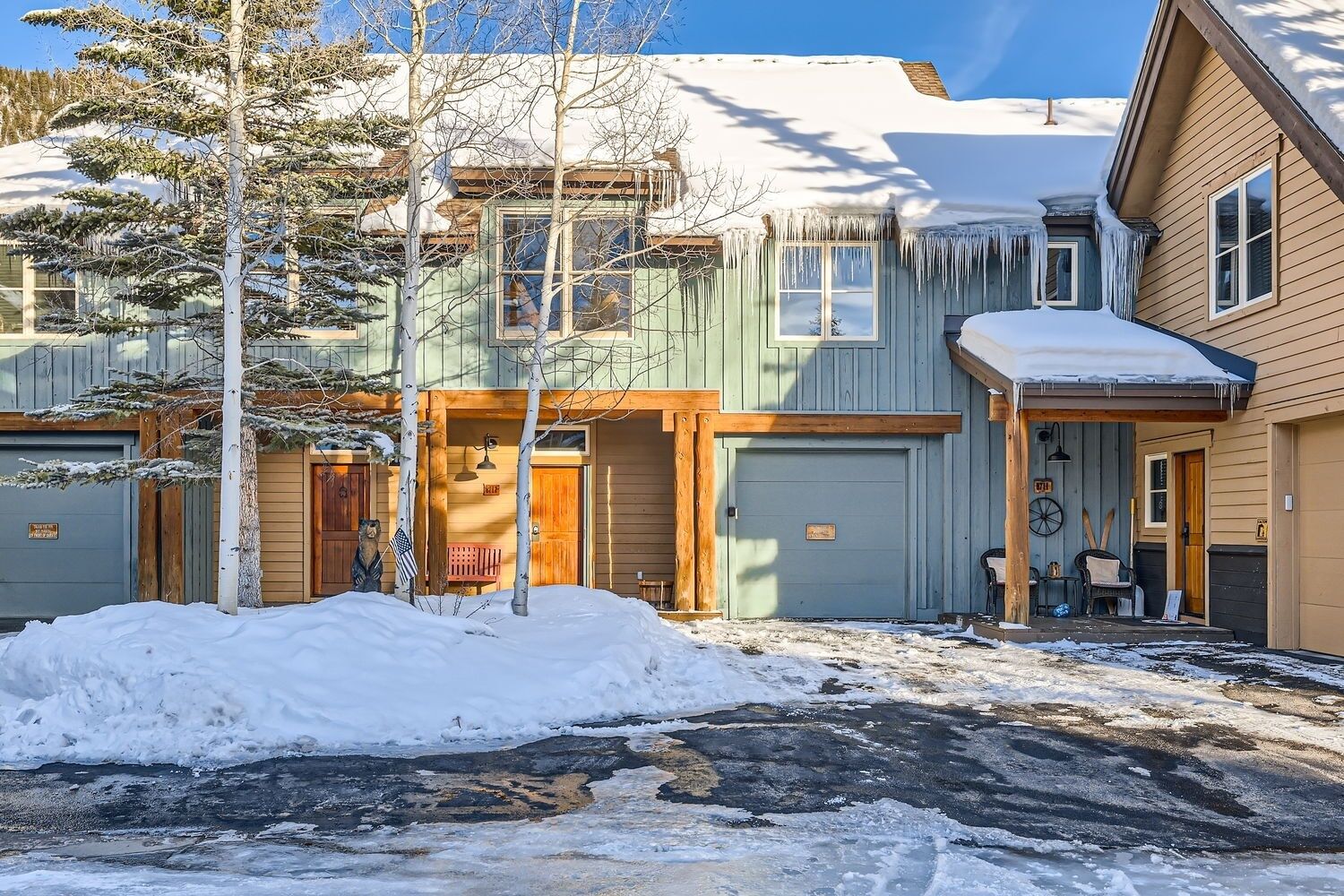 A two-story building with a garage and a covered porch.