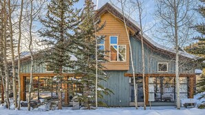 A wooden cabin with a sloped roof, surrounded by snow-covered ground and trees. - 8712 Ski Tip Townhomes 3 Bedroom Townhouse (Keystone)