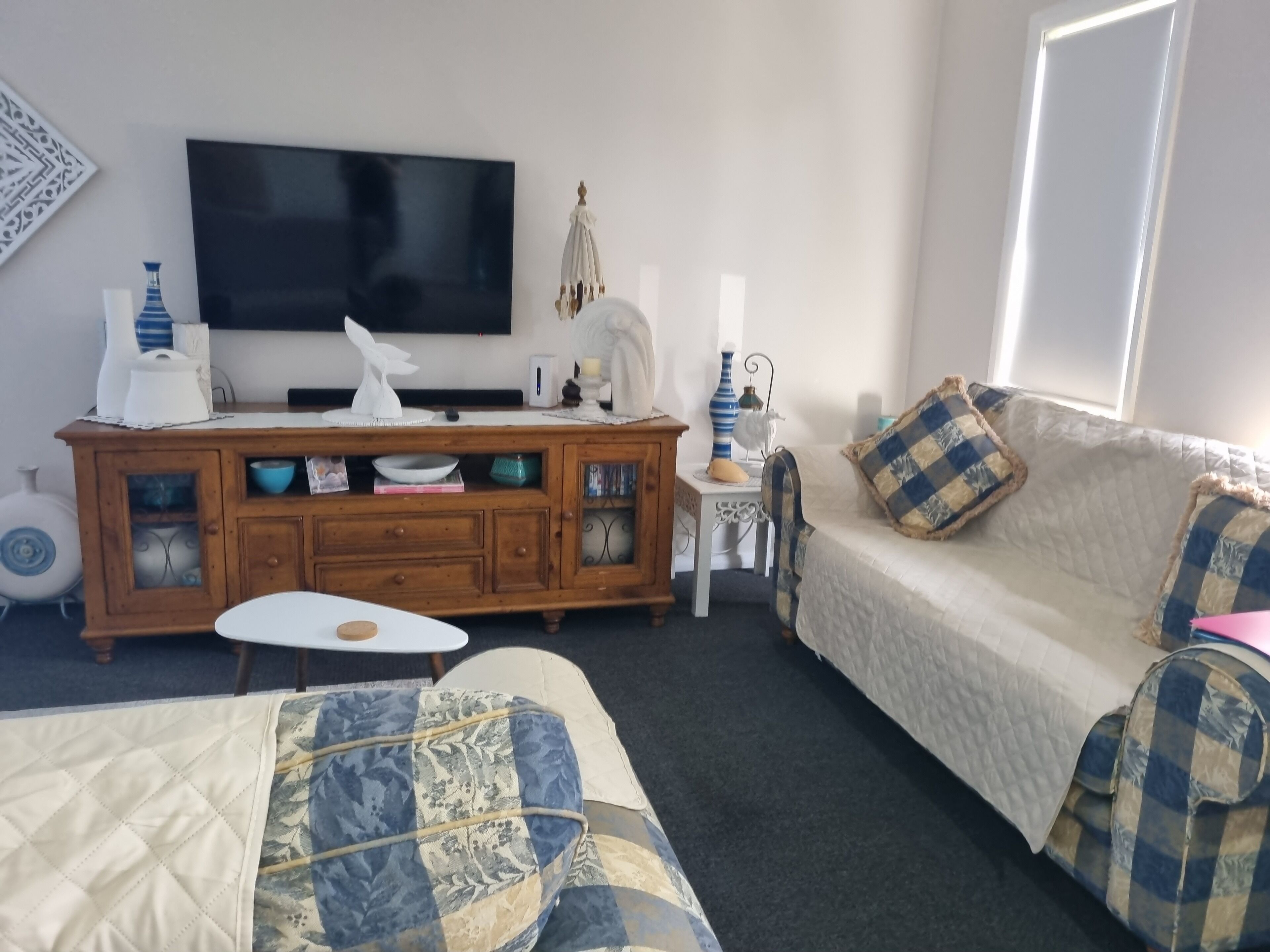 Una habitación con una cama, un sofá, un televisor, un armario y una ventana.