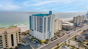 A high-rise hotel with multiple floors, a beach view, and a parking lot. - 🐠🌞Oceanfront | Corner Unit | Resort Amenities | Seaside Resort 603 (North Myrtle Beach)