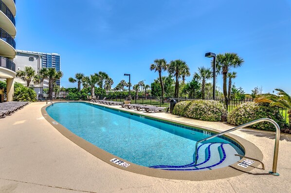 A swimming pool with a 3 FT depth marker, surrounded by palm trees and a building in the background. - 🌴🐠Lazy River + Indoor/Outdoor Pools | Oceanfront | South Wind 205 (Myrtle Beach)