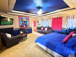 A bedroom with a large bed, a sofa, a TV, and a ceiling fan. - GolfSim HotTub PS5 Sauna Thtr Pooltbl 6BR 5BA 420 (Thornton, CO, 80602)