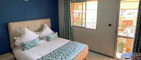 A bedroom with a bed, a window, a ceiling light, and an air conditioning unit.