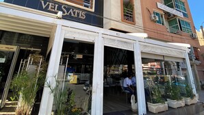 Ein mehrstöckiges Gebäude mit einer Schaufensterschrift, die "VELSATIS" zeigt.
